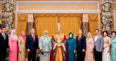 Agong With Nine Foreign Representatives In A Formal Setting.