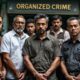 Individuals In Handcuffs Outside A Police Station In Malaysia.