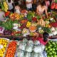 Colorful Malaysian Market With Fresh Produce And Shoppers.