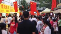 Crowd At Malaysian Cultural Event With China Flags.