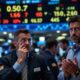 Traders On A Busy Stock Exchange Floor Looking Concerned.