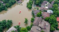 Flooded Neighborhoods In Malaysia With Submerged Homes And Boats.