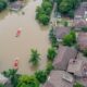 Flooded Neighborhoods In Malaysia With Submerged Homes And Boats.