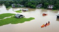 Flooded Area In Malaysia With Rescue Teams And Homes Underwater.