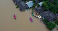 Flooded Area In Malaysia With Rescue Boats And Debris.