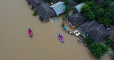 Flooded Area In Malaysia With Rescue Boats And Debris.