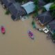 Flooded Area In Malaysia With Rescue Boats And Debris.